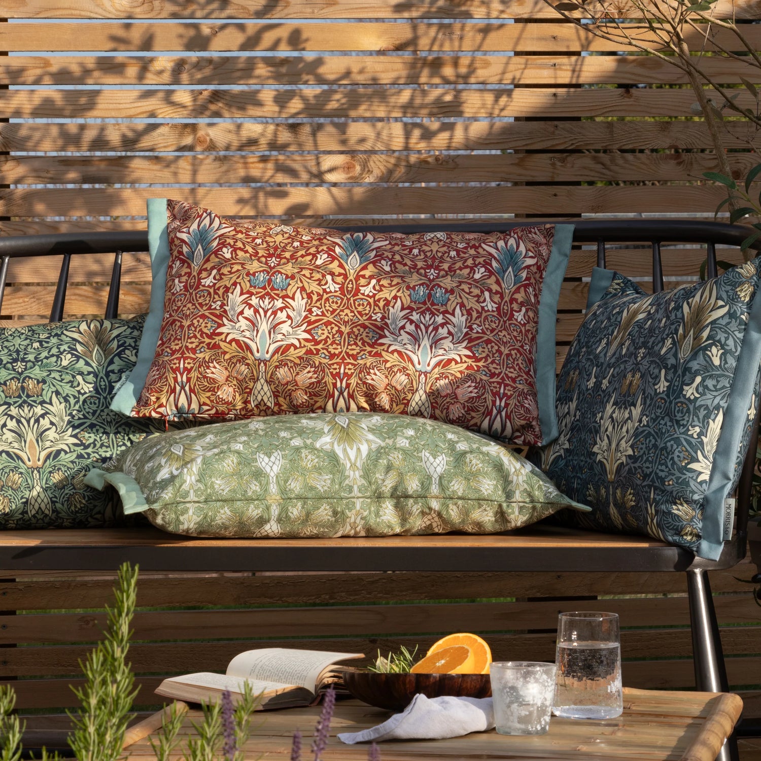 Decorative pillows on a wooden bench with a table in front